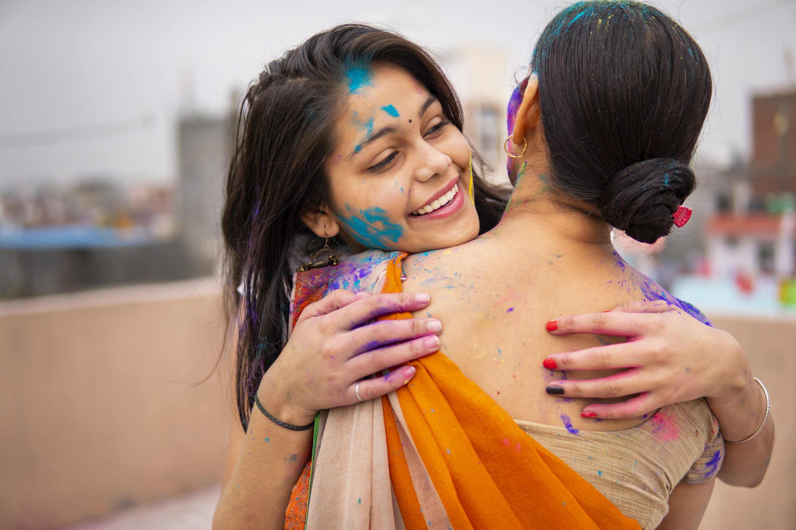 Happy Indian mother daughter celebrating the Holi festival together.
